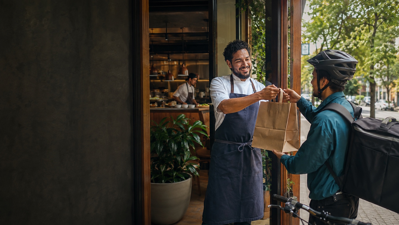 Restaurante entregando un pedido directo a un repartidor durante el día
